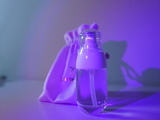 Frasco do lubrificante Nectar em uma composição com iluminação roxa